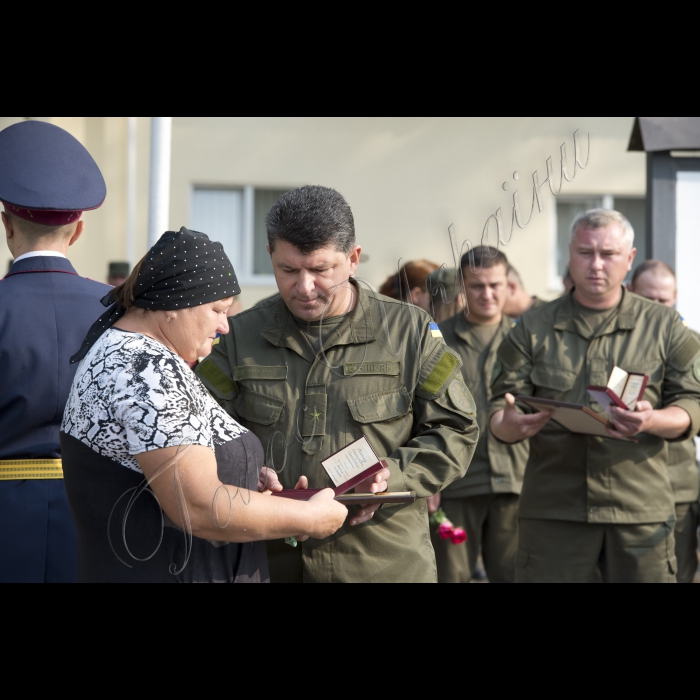 03 вересня 2015
Голова ВР України Володимир Гройсман взяв участь у церемонії прощання із військовослужбовцями Дмитром Сластніковим та Олександром Костиною, які загинули від отриманих поранень під час сутичок під будівлею Верховної Ради України 31 серпня (військова частина №3027 Національної гвардії України, с. Нові Петрівці).
Заступник командувача Національної гвардії України по роботі з особовим складом генерал-майор Ярослав Сподар вручає посмертну нагороду орден «За мужність» III ступеня родичці Олександра Костини