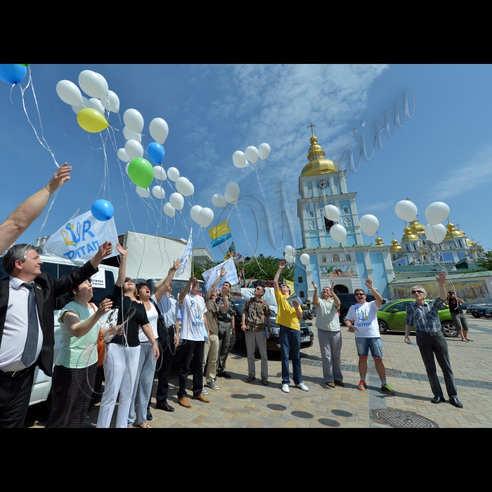Київ. Об'єднання колон учасників автопробігу на Михайлівській площі, де відбудеться символічний запуск білих повітряних кульок та білих голубів миру, як ознаки єднання справжніх громадян своєї країни - патріотів України.