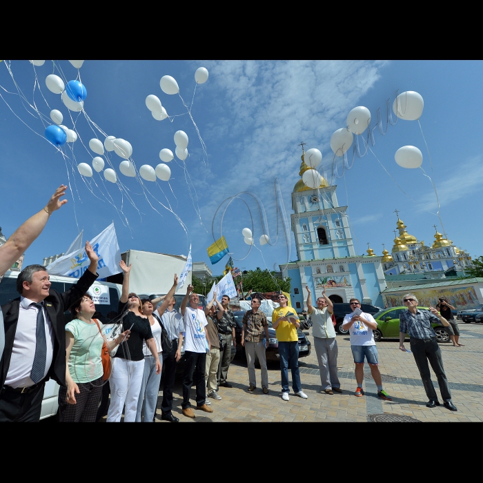 Київ. Об'єднання колон учасників автопробігу на Михайлівській площі, де відбудеться символічний запуск білих повітряних кульок та білих голубів миру, як ознаки єднання справжніх громадян своєї країни - патріотів України.