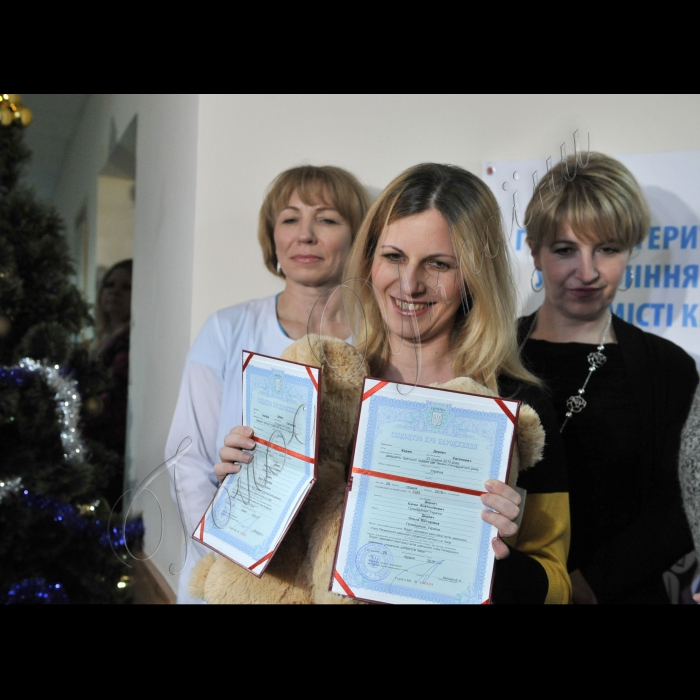 У Київському  пологовому будинку № 1 відбувся Всеукраїнський флешмоб - урочисте вручення свідоцтва про народження дітей, які народилися у період з 31 грудня  2015 року по 03 січня 2016 року. Акція відбулась в усіх містах обласного значення, які приєдналися до пілотного проекту Міністерства юстиції України, зокрема й  місті Києві.
Ольга Деркач зі свідоцтвами про народження двох братиків.