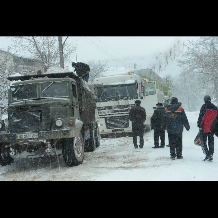 Тернопільська область, Підгаєцький район. Місцеві служби Автодору допомагають вантажним авто заїзжати на круті підйоми, занесені снігом.
