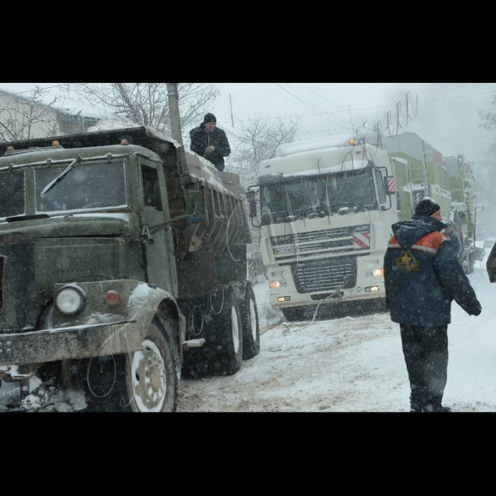 Тернопільська область, Підгаєцький район. Місцеві служби Автодору допомагають вантажним авто заїзжати на круті підйоми, занесені снігом.
