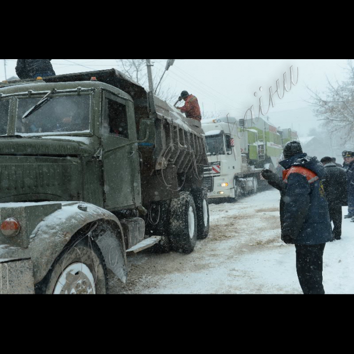 Тернопільська область, Підгаєцький район. Місцеві служби Автодору допомагають вантажним авто заїзжати на круті підйоми, занесені снігом.
