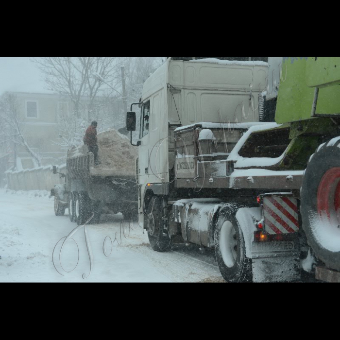 Тернопільська область, Підгаєцький район. Місцеві служби Автодору допомагають вантажним авто заїзжати на круті підйоми, занесені снігом.
