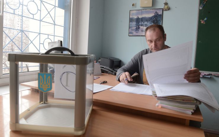 Підготовка до виборів Президента України. Виборча дільниця 800129 округ 212 Дарницький район м. Києва. Член ДВК Олександр Соломанюк звіряє списки виборців