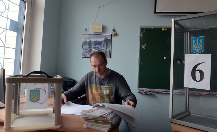 Підготовка до виборів Президента України. Виборча дільниця 800129 округ 212 Дарницький район м. Києва. Член ДВК Олександр Соломанюк звіряє списки виборців