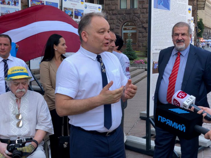 26 червня 2019 Київ. День Кримськотатарського національного прапору.  
Під стінами міськдержадміністрації та у колонному залі КМДА демонстрували світлини з виставки «Об'єднані прапором - #LIBERATECRIMEA».
Активіст Микола Подрізан, Ескендер Барієв, координатор акції “Об'єднані прапором – #LIBERATECRIMEA”, голова правління Кримськотатарського Ресурсного Центру, нар. деп. Рефат Чубаров.