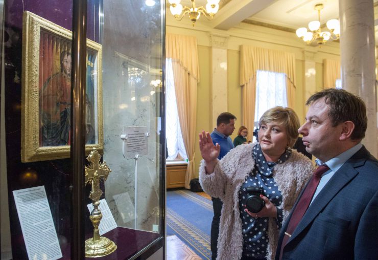 Презентація одноденної експозиції Національного Києво-Печерського історико-культурного заповідника, що присвячена новорічно-різдвяним святкуванням в Україні

  Національний Києво-Печерський історико-культурний заповідник на честь Василя Великого та свята Водохрещі в кулуарах другого поверху будинку Верховної Ради України представив одноденну експозицію з фондів Заповідника, на якій можна побачити ікону «Трійця Новозавітна» та хрест напрестольний з композицією «Хрещення» (Богоявлення).

Майстри іконопису використовували 3D технології ще у ХVIII-XIX століттях! Ікона «Трійця Новозавітна»  належить до того рідкісного типу, що історіографії отримав назву трисценорама ( з грецької: три, сцена, вид) й означає художній виріб на якому під різними кутами видно  три зображення. Інколи такі ікони називають ще «Троєзорами».
Унікальна ікона «Трійця Новозавітна» ( ХІХ ст.) з фондів Національного Києво-Печерського історико-культурного заповідника тривалий час займала видне місце в церкві «Всіх Святих» на горі Щекавиця в Києві, а з 30-х роках минулого століття її було передано в Музей. Нещодавно ікону  реставрували.
Головний консультант апарату ВР України Мирослава Збожна, Перший заступник Керівника Апарату ВР України Володимир Слишинський

