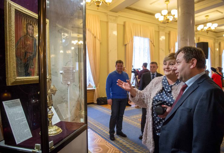 Презентація одноденної експозиції Національного Києво-Печерського історико-культурного заповідника, що присвячена новорічно-різдвяним святкуванням в Україні

  Національний Києво-Печерський історико-культурний заповідник на честь Василя Великого та свята Водохрещі в кулуарах другого поверху будинку Верховної Ради України представив одноденну експозицію з фондів Заповідника, на якій можна побачити ікону «Трійця Новозавітна» та хрест напрестольний з композицією «Хрещення» (Богоявлення).

Майстри іконопису використовували 3D технології ще у ХVIII-XIX століттях! Ікона «Трійця Новозавітна»  належить до того рідкісного типу, що історіографії отримав назву трисценорама ( з грецької: три, сцена, вид) й означає художній виріб на якому під різними кутами видно  три зображення. Інколи такі ікони називають ще «Троєзорами».
Унікальна ікона «Трійця Новозавітна» ( ХІХ ст.) з фондів Національного Києво-Печерського історико-культурного заповідника тривалий час займала видне місце в церкві «Всіх Святих» на горі Щекавиця в Києві, а з 30-х роках минулого століття її було передано в Музей. Нещодавно ікону  реставрували.
Головний консультант апарату ВР України Мирослава Збожна, Перший заступник Керівника Апарату ВР України Володимир Слишинський
